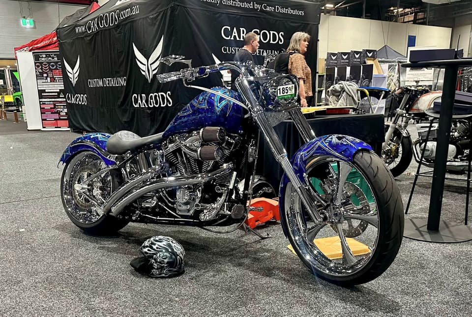 Blue custom Softail with chrome wheels on a display stand