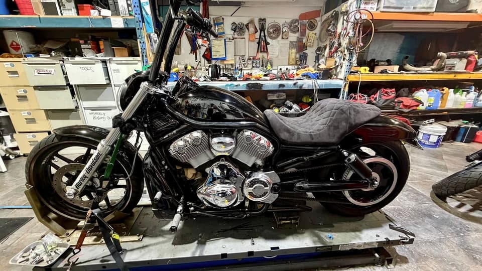 Black V-Rod on the lift in front of the parts shelving