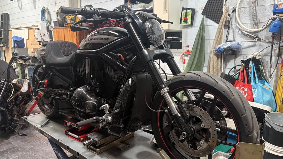Black V-Rod Night Rod on the workshop lift, front three-quarter view